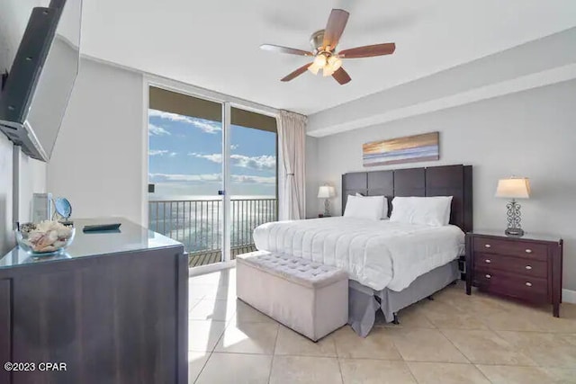 tiled bedroom featuring ceiling fan, a wall of windows, and access to outside