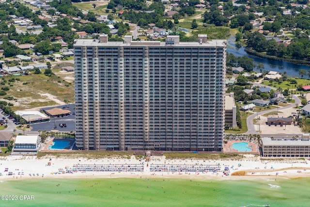 birds eye view of property with a water view and a beach view