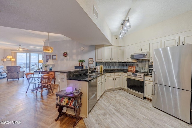 kitchen featuring kitchen peninsula, appliances with stainless steel finishes, ceiling fan, a textured ceiling, and sink