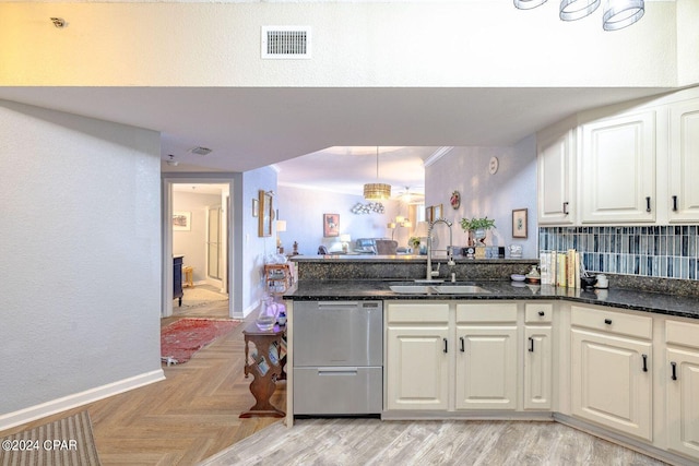 kitchen featuring dark stone countertops, white cabinets, sink, dishwasher, and light parquet floors