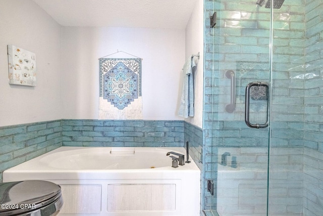 bathroom with toilet, shower with separate bathtub, and a textured ceiling