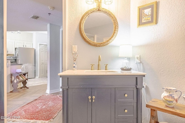 bathroom featuring parquet flooring and vanity