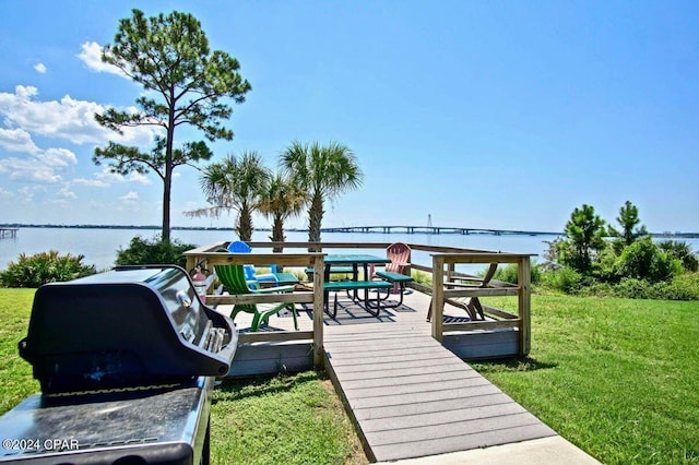 deck with a lawn and a water view