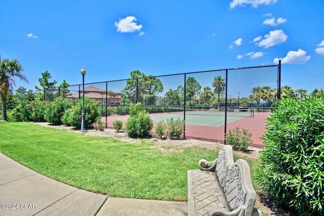 view of tennis court featuring a yard