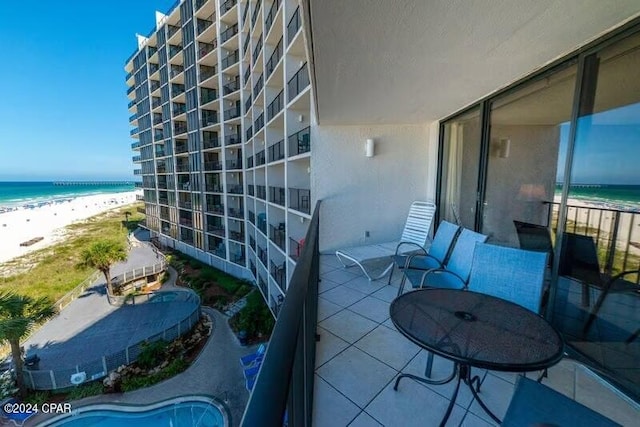 balcony featuring a beach view and a water view