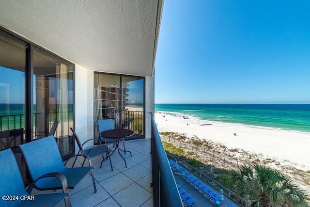 balcony featuring a water view and a view of the beach