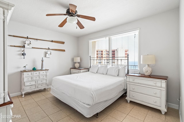 tiled bedroom with a textured ceiling and ceiling fan