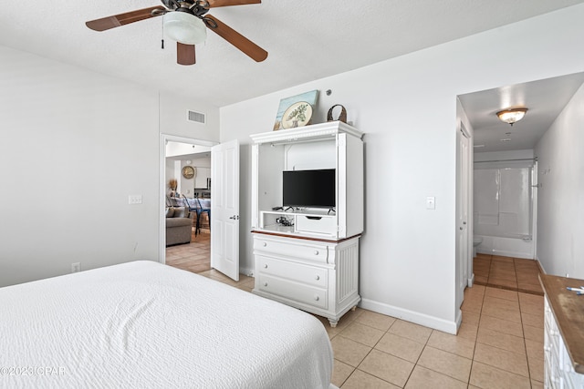 tiled bedroom with a textured ceiling and ceiling fan