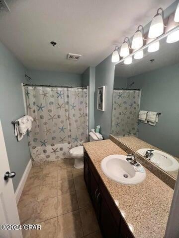 bathroom with tile floors, toilet, and large vanity