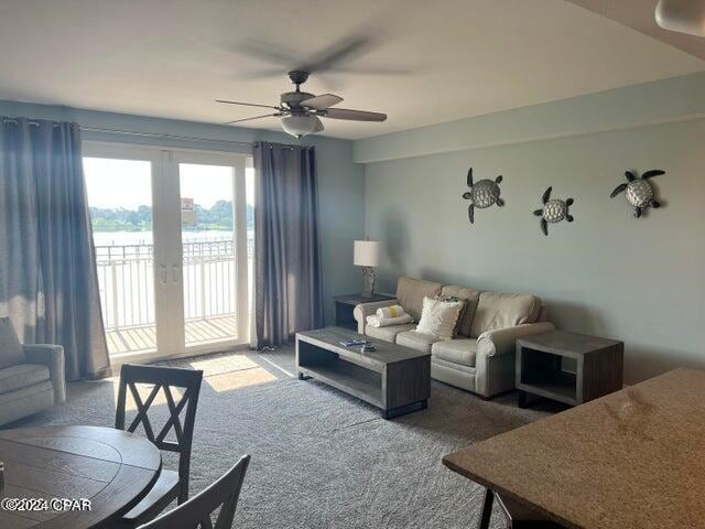 living room with french doors, ceiling fan, and carpet