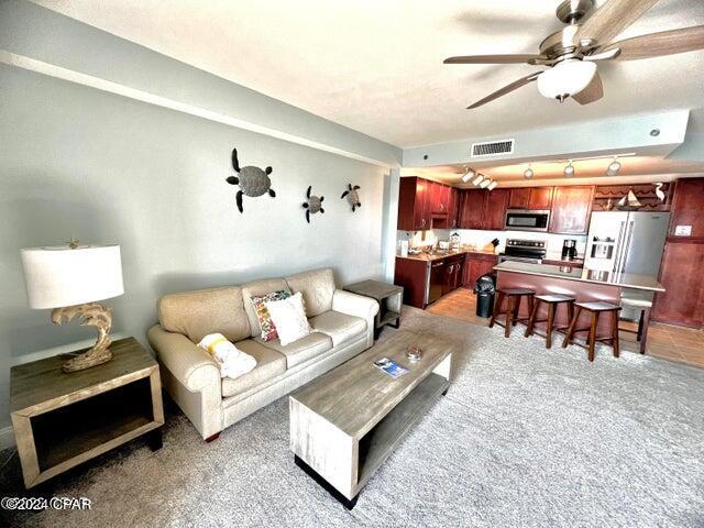 living room featuring ceiling fan and carpet floors