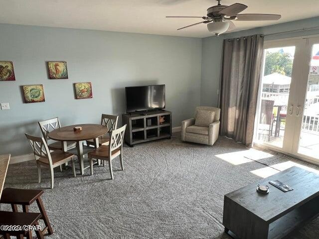 carpeted living room with ceiling fan