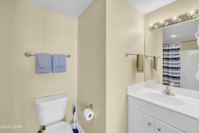 bathroom with vanity, toilet, and curtained shower