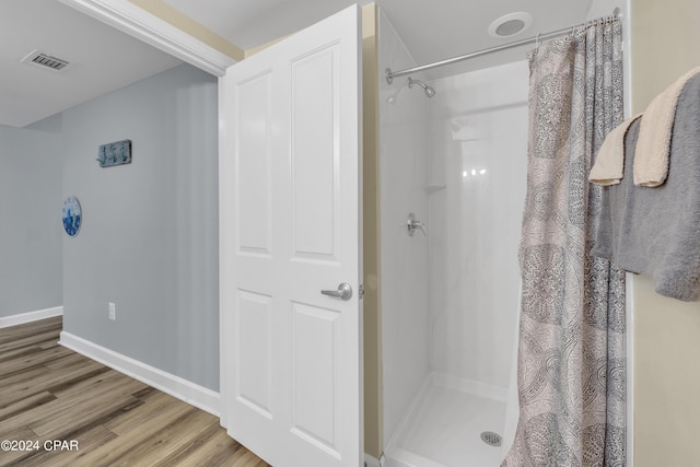 bathroom with wood-type flooring and a shower with shower curtain