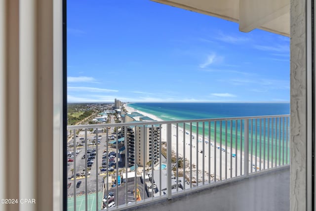 balcony with a water view and a view of the beach