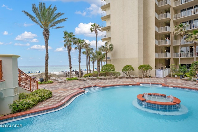 view of pool featuring a patio and a water view