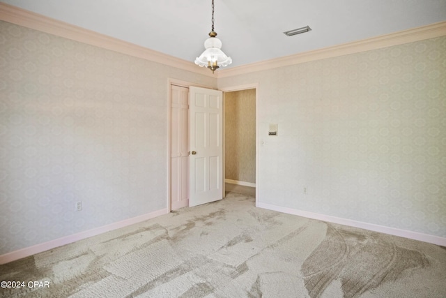 spare room with crown molding and carpet flooring