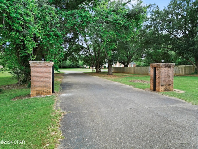 view of gate with a lawn