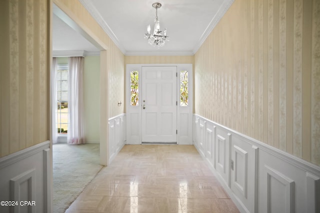 entrance foyer with light colored carpet, crown molding, and a chandelier