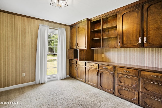 kitchen with light colored carpet and ornamental molding