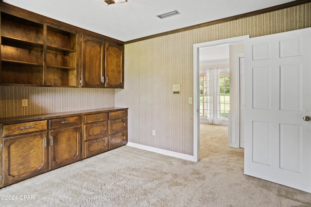 kitchen featuring ornamental molding and light carpet