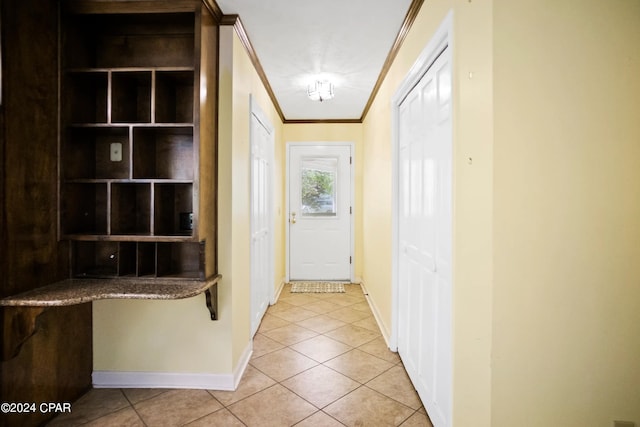 hall with light tile flooring and ornamental molding