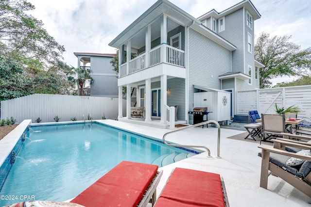 view of swimming pool with pool water feature and a patio area