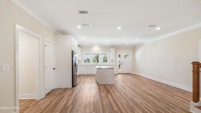 kitchen featuring light hardwood / wood-style floors, white cabinets, crown molding, and a kitchen island