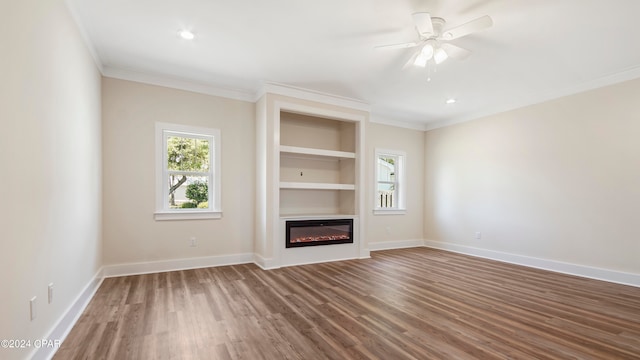 unfurnished living room featuring crown molding, built in features, ceiling fan, and hardwood / wood-style floors