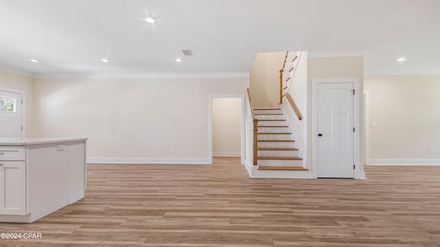 interior space with ornamental molding and light wood-type flooring