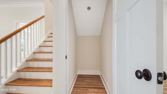 stairs with dark wood-type flooring and vaulted ceiling