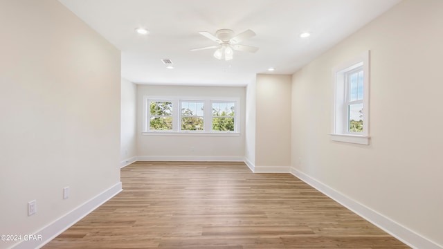 empty room with ceiling fan and light hardwood / wood-style flooring