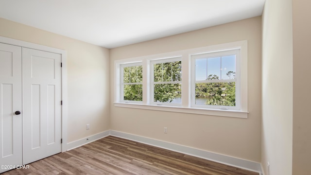 unfurnished bedroom with a closet and hardwood / wood-style floors