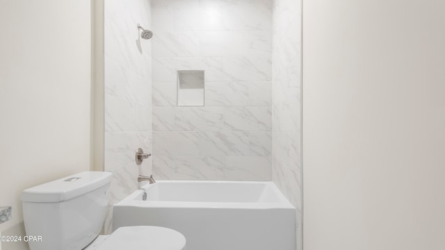 bathroom with tiled shower / bath combo and toilet