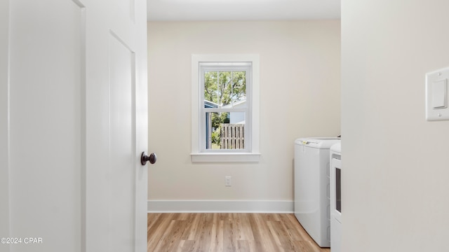 laundry room featuring washer and clothes dryer and light wood-type flooring