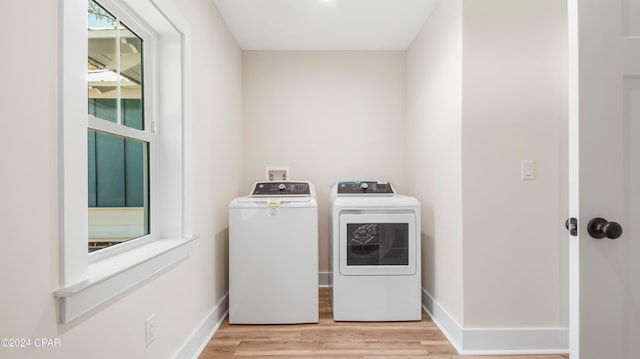 clothes washing area with hookup for a washing machine, light wood-type flooring, and washing machine and clothes dryer