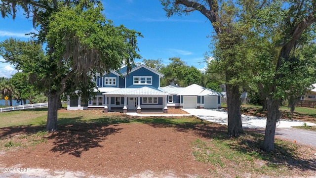 view of front of property with a garage, a front lawn, and covered porch