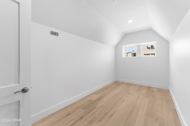 additional living space featuring lofted ceiling and light wood-type flooring