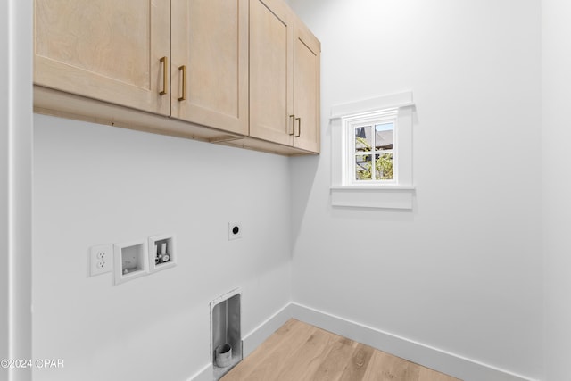 clothes washing area featuring hookup for an electric dryer, cabinets, light wood-type flooring, and washer hookup