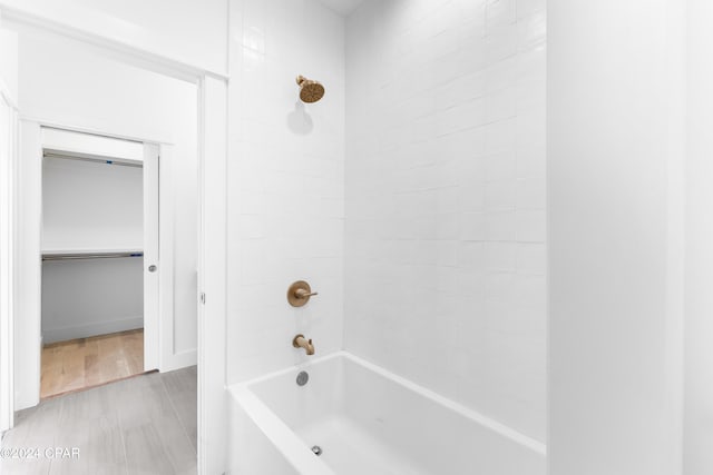 bathroom with wood-type flooring and tiled shower / bath