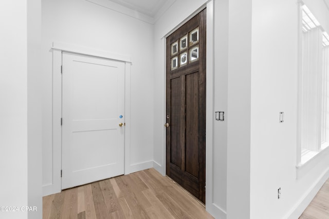 foyer entrance featuring ornamental molding and light hardwood / wood-style floors