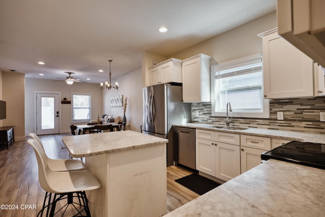 kitchen featuring white cabinets, sink, light wood-type flooring, and stainless steel appliances