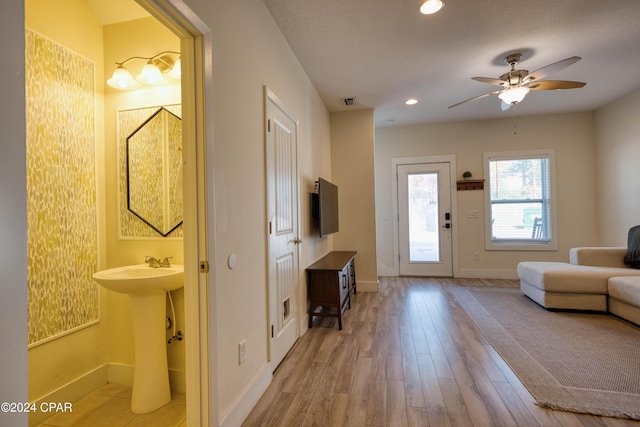 living room featuring ceiling fan, sink, and hardwood / wood-style flooring