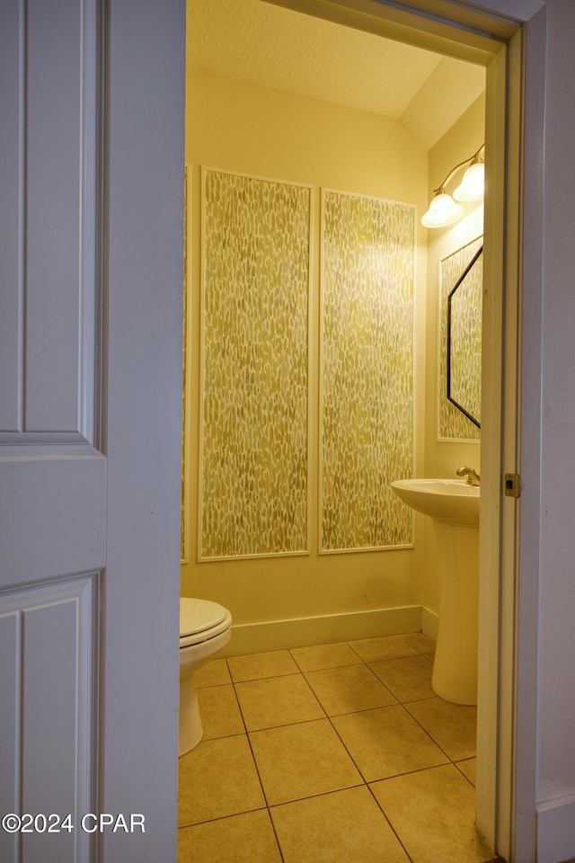 bathroom featuring toilet, tile patterned floors, and lofted ceiling