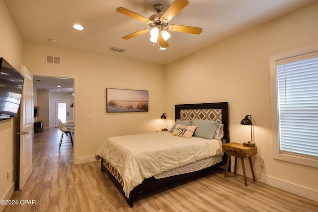 bedroom featuring multiple windows, ceiling fan, and light hardwood / wood-style flooring