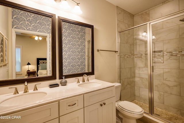 bathroom with vanity, ceiling fan, toilet, and walk in shower