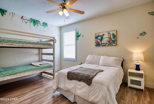 bedroom with a textured ceiling, hardwood / wood-style flooring, and ceiling fan