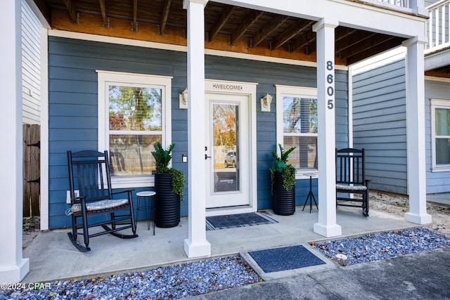 doorway to property with covered porch and a balcony