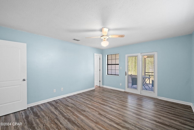 spare room featuring dark wood-type flooring, ceiling fan, and a textured ceiling