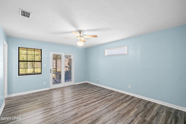 spare room featuring dark hardwood / wood-style floors, a textured ceiling, and ceiling fan